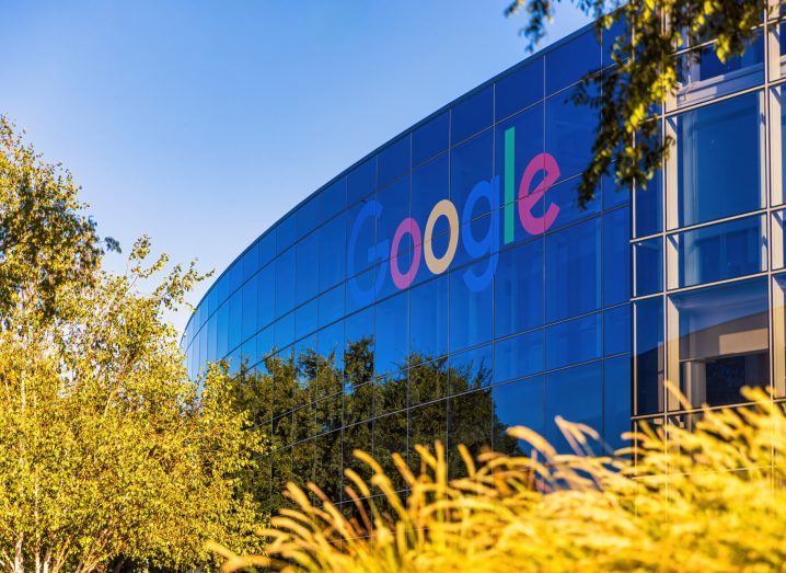 Google logo on a building with grass in the foreground.