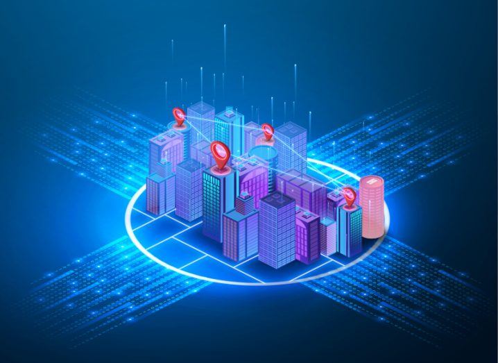 Illustration of multiple city buildings surrounded by a blue digital circle and paths stemming out from four parts of the circle. Used as a concept for smart cities.