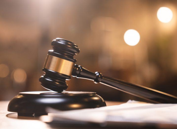 A court gavel on a desk, with blurred paper in front of it.