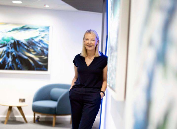 A woman standing by a wall in an office. She is Catherine Doyle of Dell Technologies Ireland.