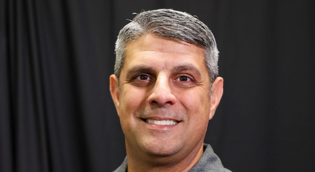 A close-up headshot of a man smiling at the camera. He is cybersecurity expert and Future Human podcast guest Neil Khatod.