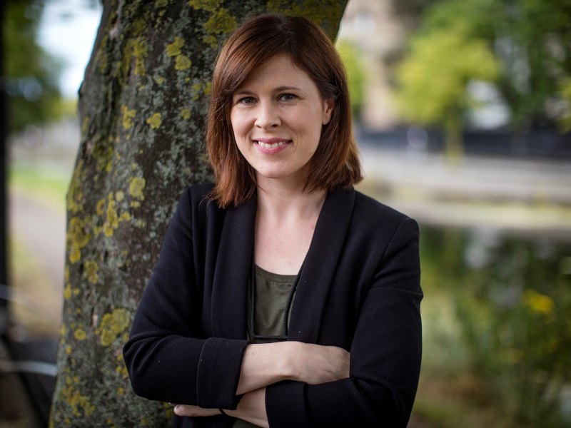 Dr Patricia Scanlon, AI ambassador for Ireland, smiles at the camera in an outdoor setting with trees in the background.