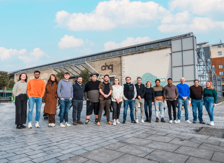 A group of men and women founders stand next to each other in front of the building that houses Dogpatch Labs.