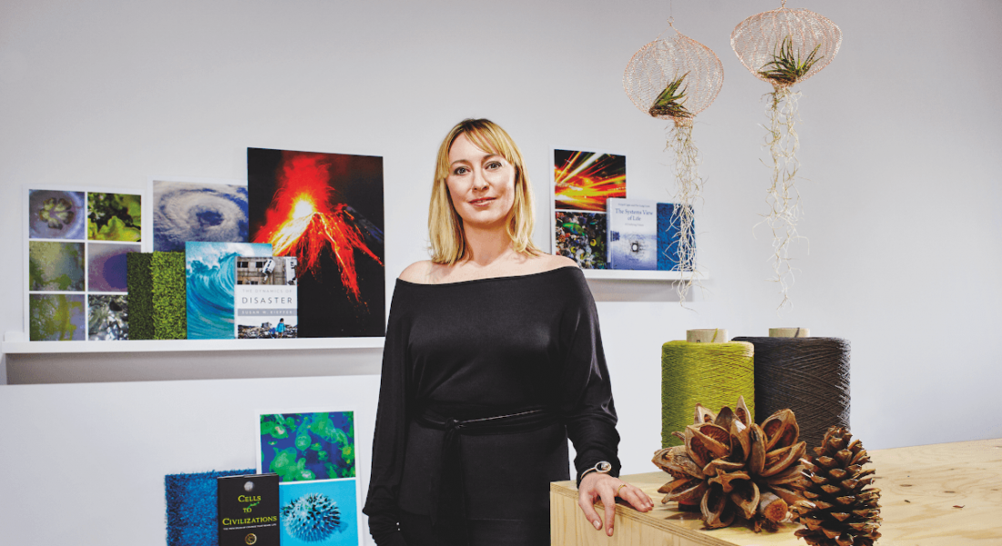 A woman with blonde hair stands in front of shelves showing books with nature images on them. She is Melissa Sterry.